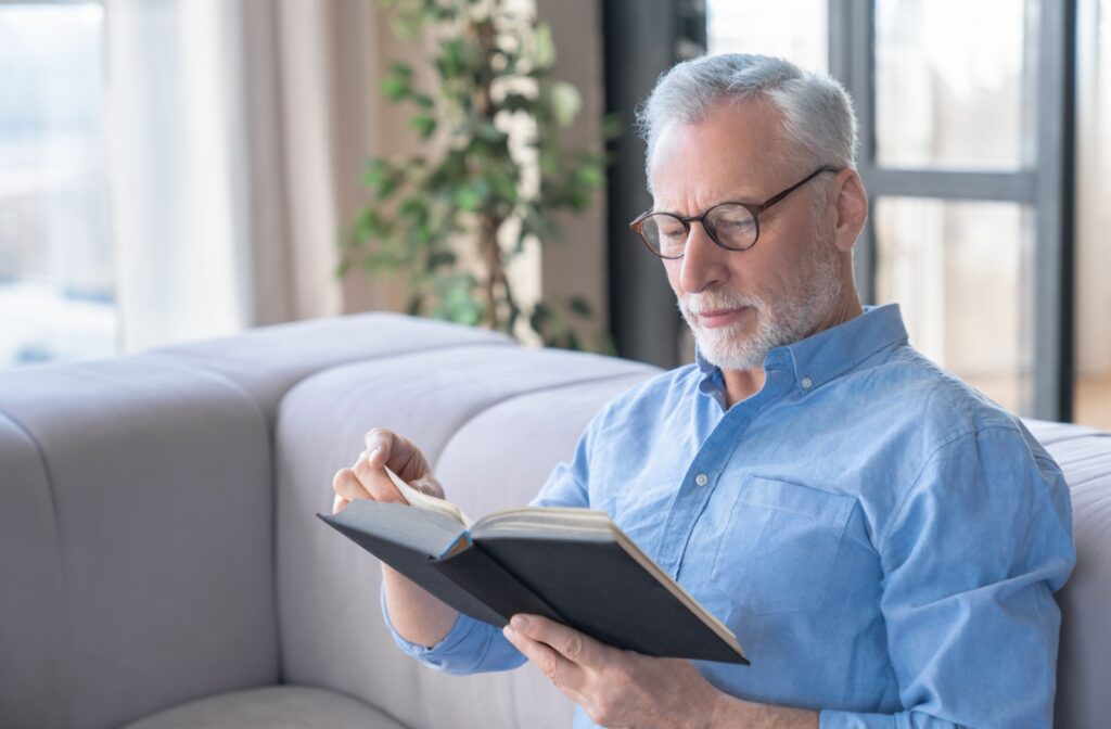 A senior relaxes and enjoys a book with no concerns of household chores in their independent living community.