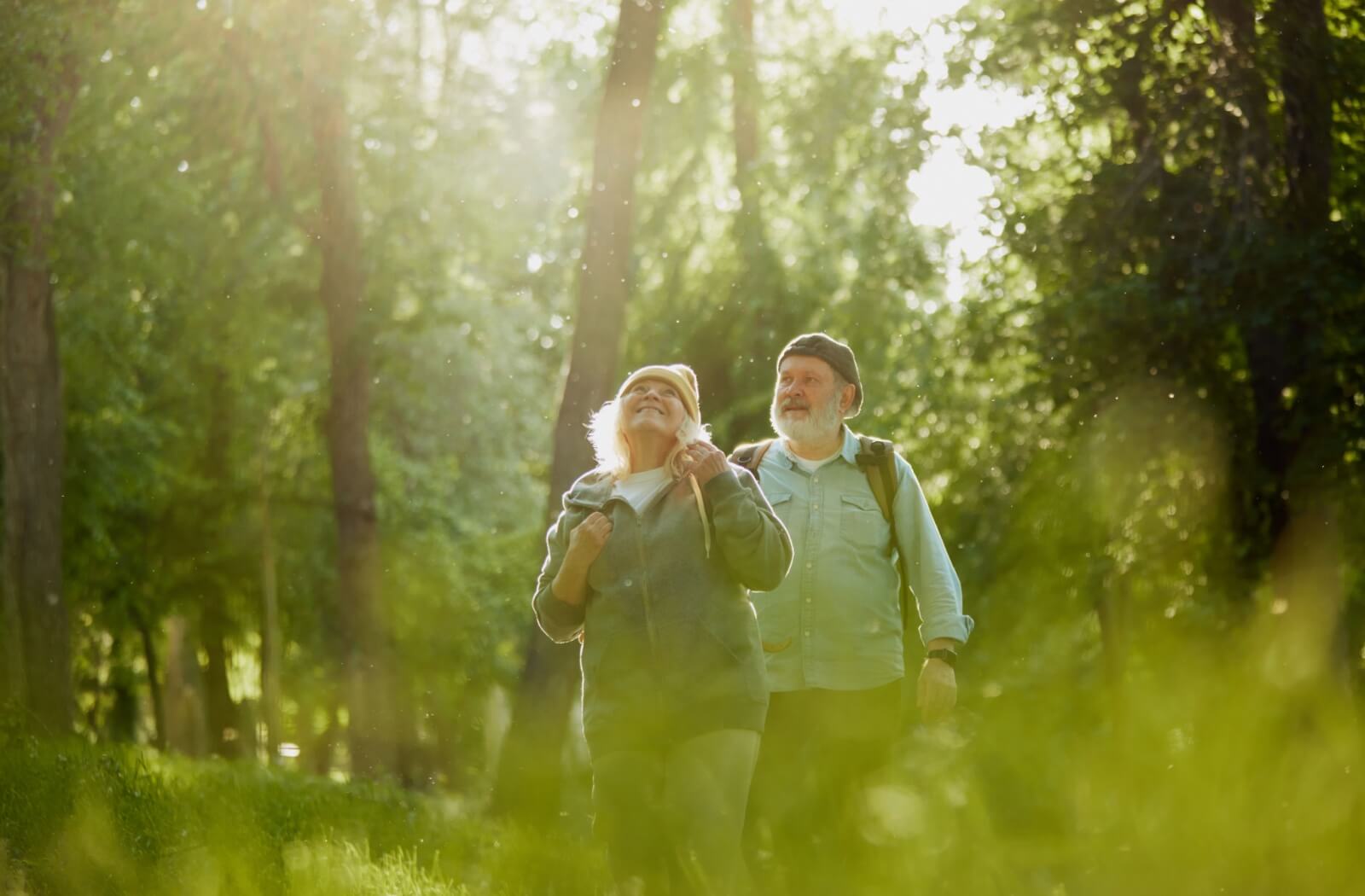 A senior couple enjoy the fresh air and greenery of a local park on a warm, spring day