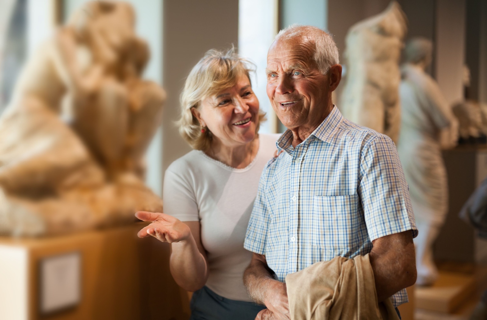 A happy senior couple delights in a recent addition to a local museum