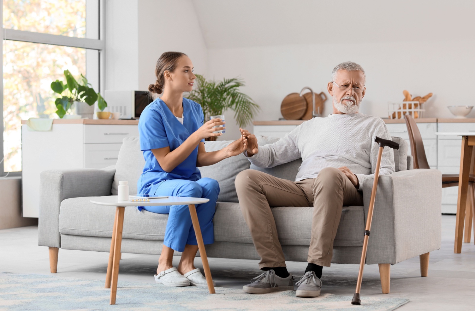 An older adult refuses to take medication offered by their caregiver.